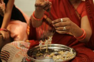 Person in Red T Shirt Holding Necklaces. Ahmadabad, India